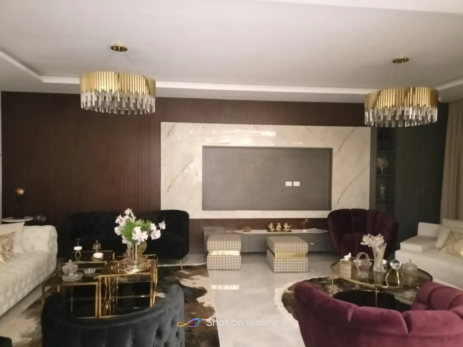 Elegant interior featuring a large TV, neutral tones, and golden chandelier accents in New Cairo from Consept Art's site work portfolio.