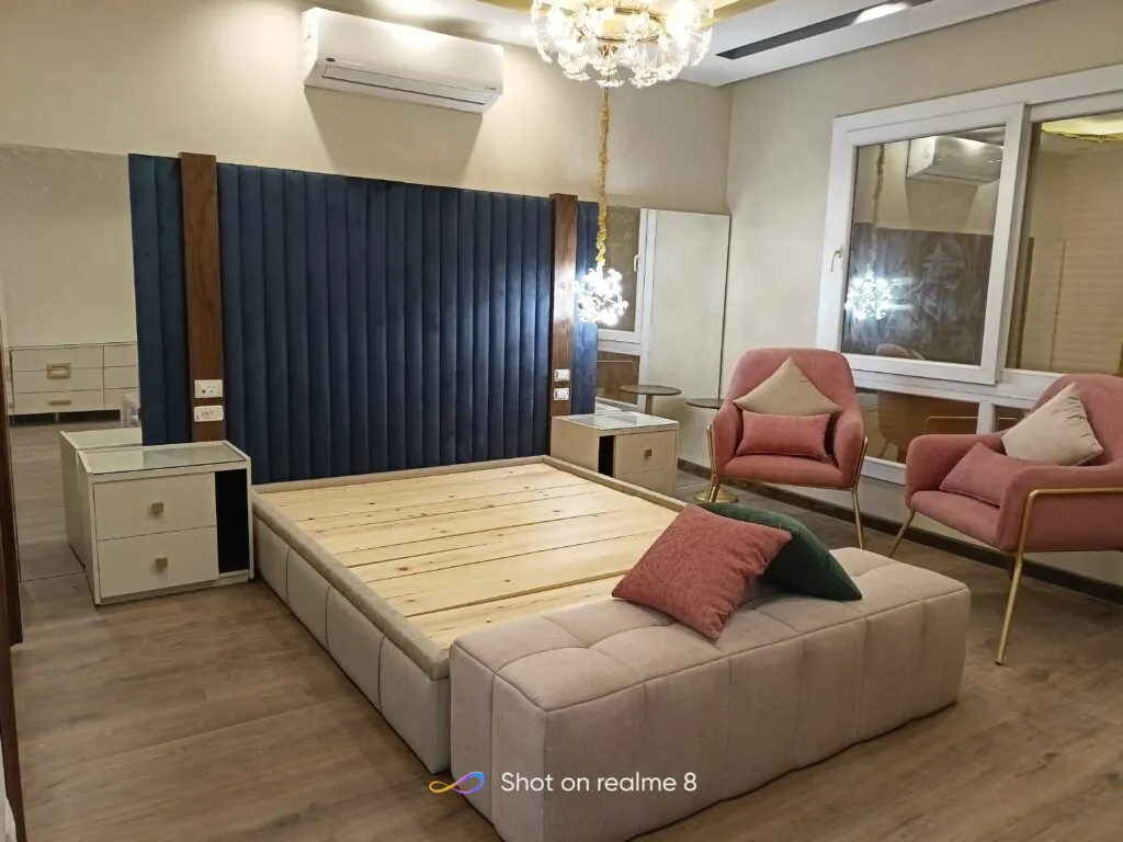 Bedroom with soft lighting, a neutral color scheme, and an upholstered wooden bed frame.
