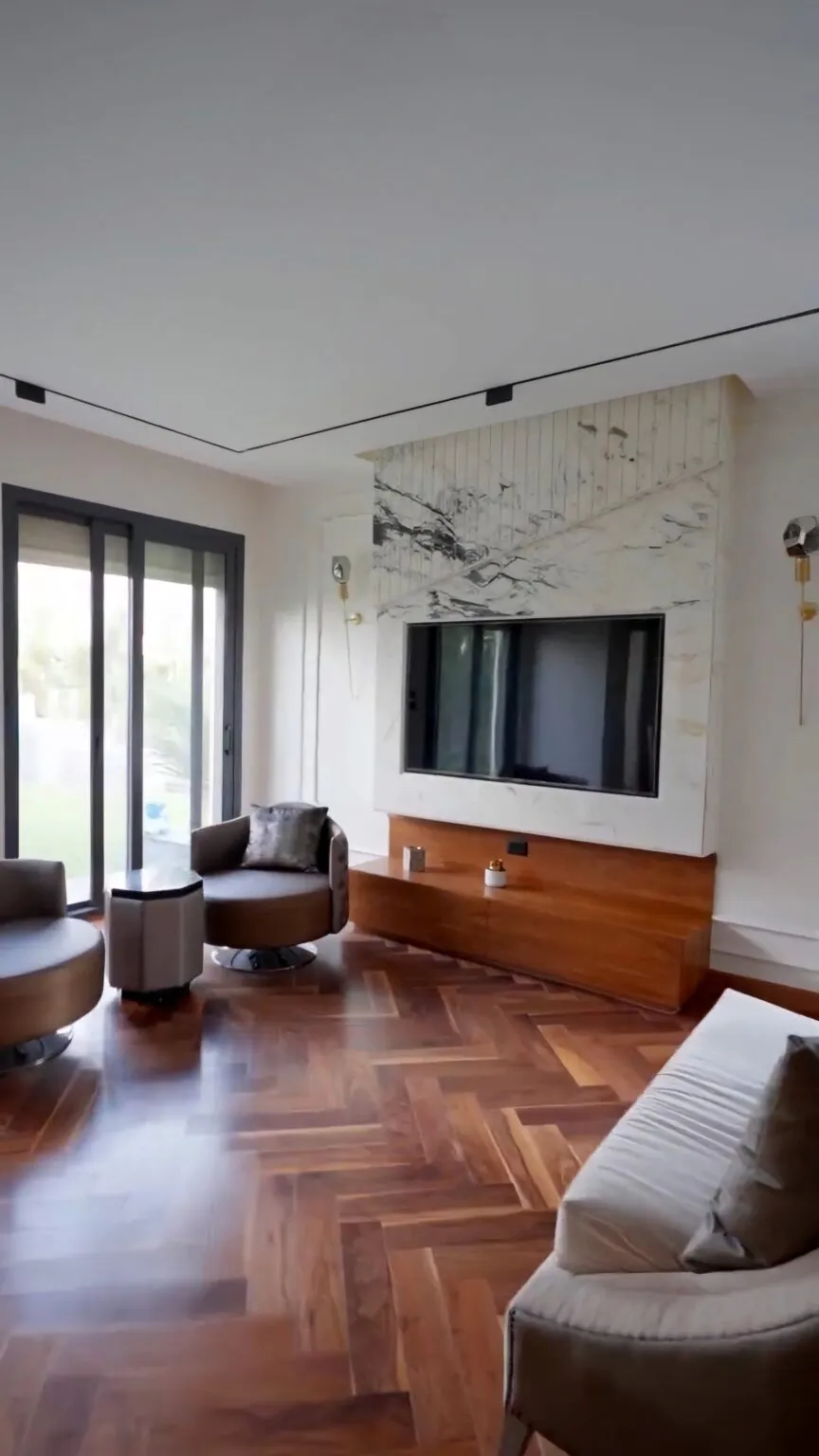 Contemporary living space with a marble-accented TV wall, a wooden console, and a cozy beige sofa from Consept Art's site work portfolio.