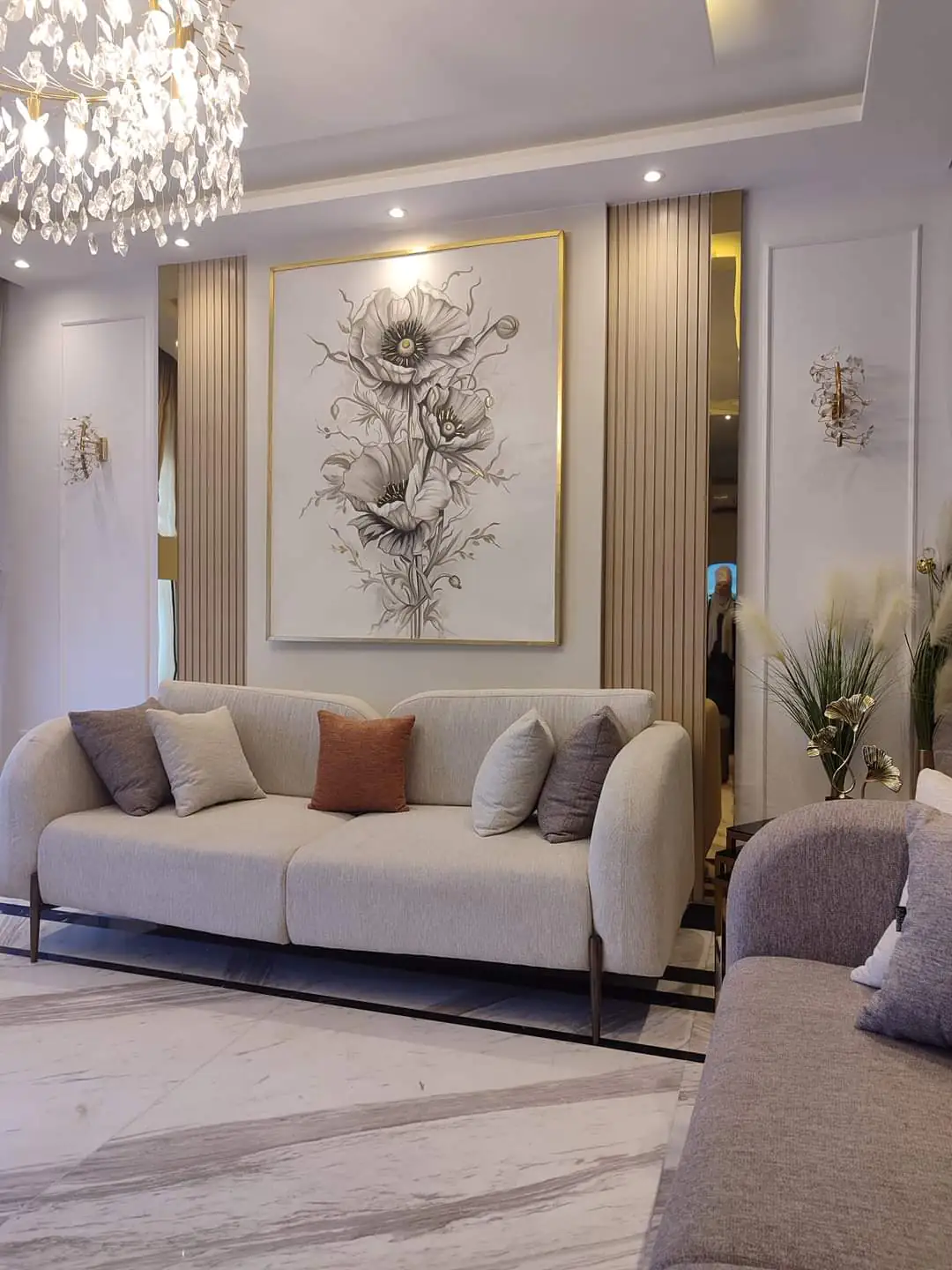Luxurious lounge area with a white sofa, custom shelving, and decorative art pieces on the wall.