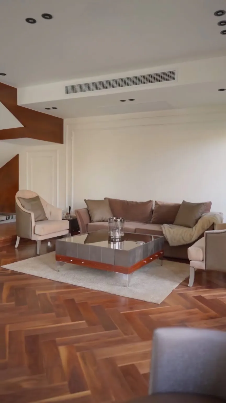Minimalist living room with clean lines, beige upholstery, and a coffee table with subtle decor.