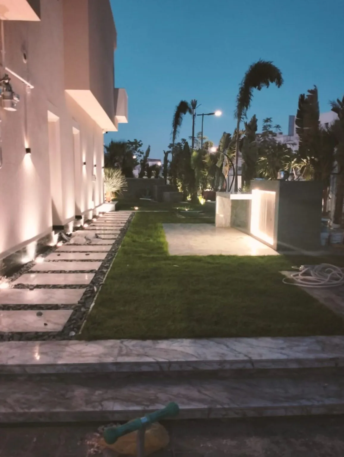 Large garden area with neatly trimmed grass, outdoor seating, and a stone patio.