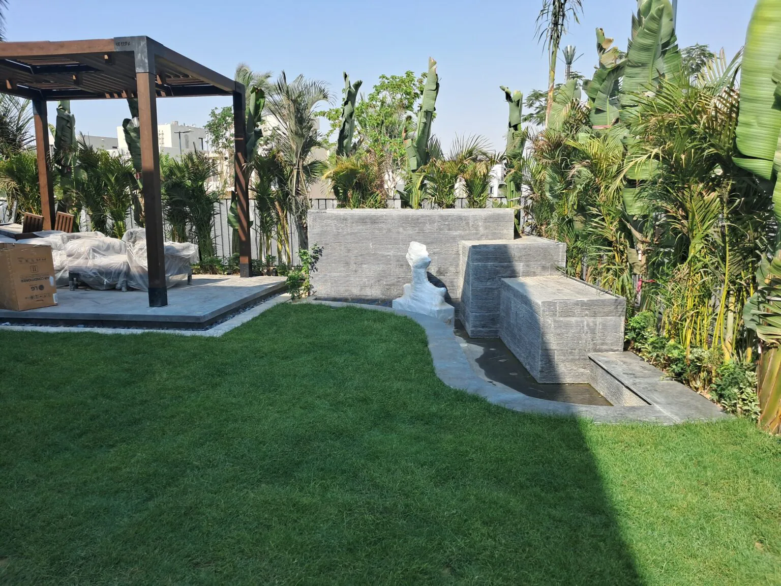 Outdoor barbeque area with modern fixtures, a pergola, and surrounding greenery from Consept Art's site work portfolio.