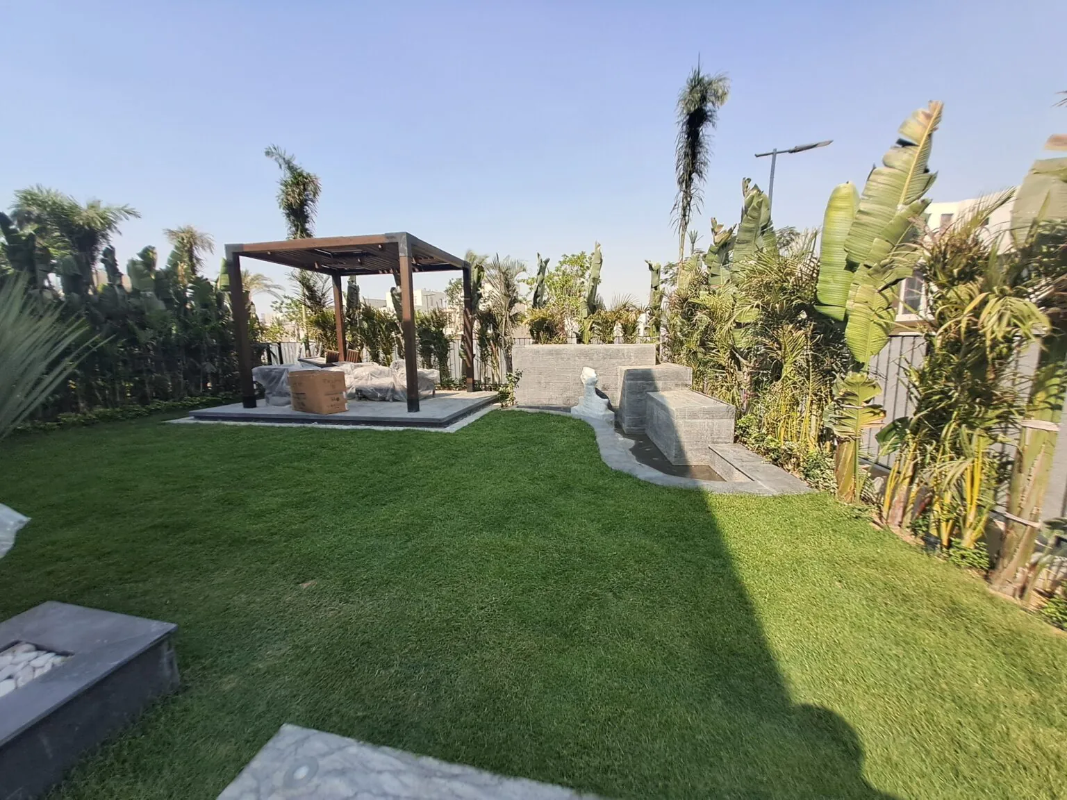 Spacious backyard featuring a landscaped lawn, stone pathways, and modern outdoor seating.