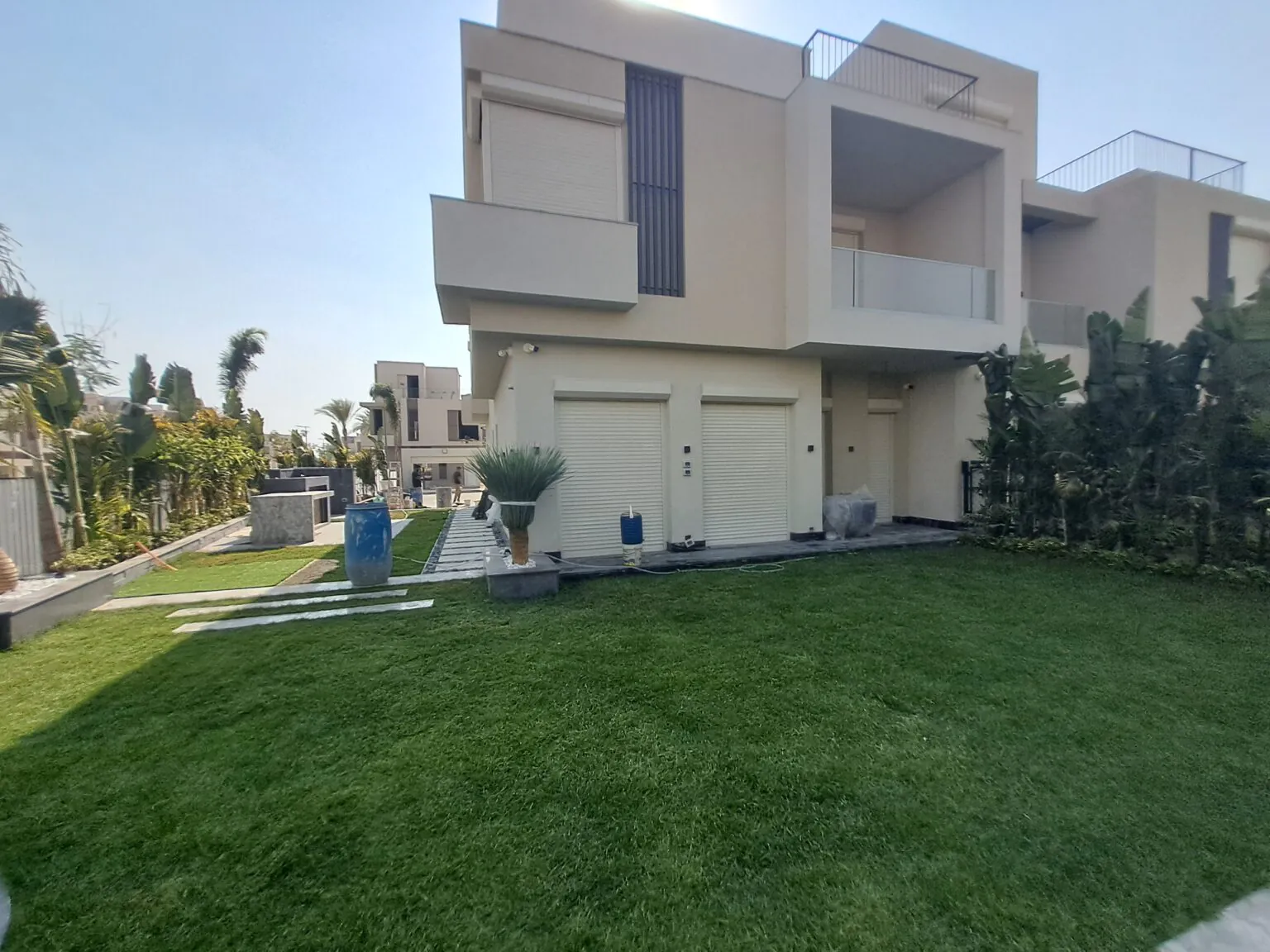 Evening outdoor setup with modern lighting, a landscaped garden, and sleek stone pathways.