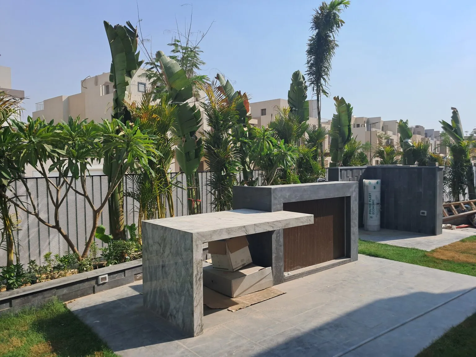 Large garden area with neatly trimmed grass, outdoor seating, and a stone patio in New Cairo