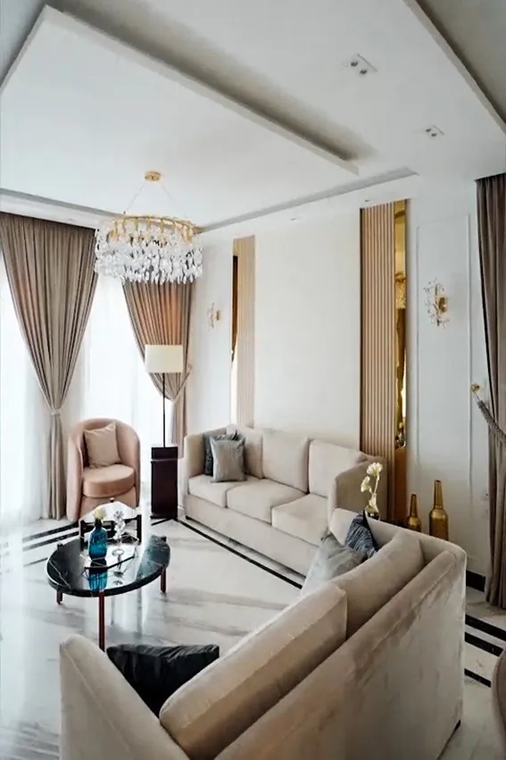 Luxurious lounge area with a white sofa, custom shelving, and decorative art pieces on the wall.