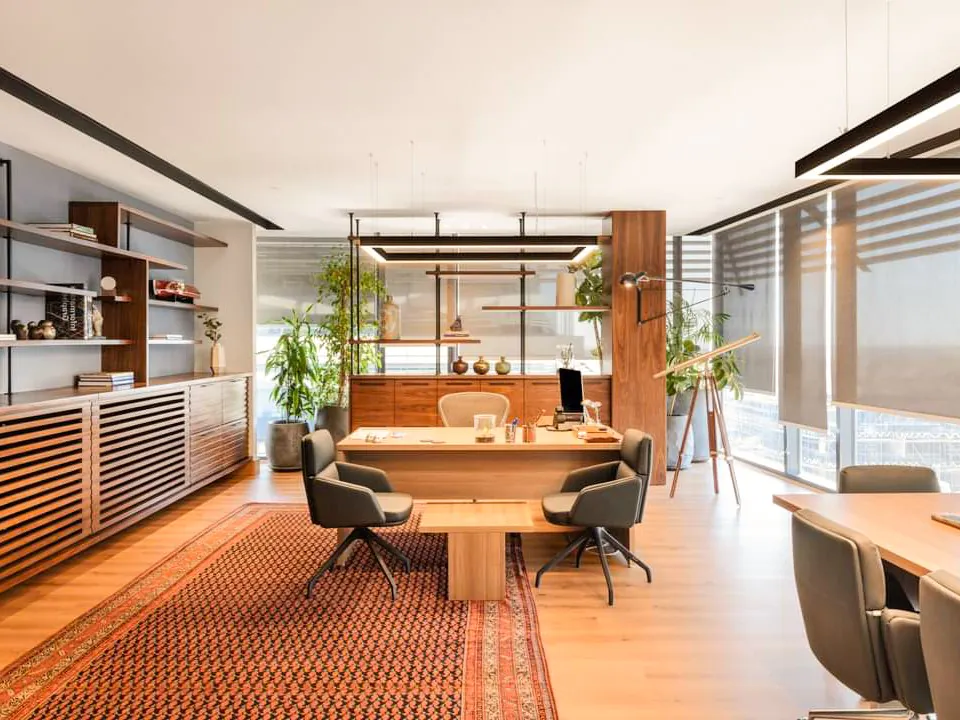 Open office space with modern desks, ergonomic chairs, and large windows, allow natural lights