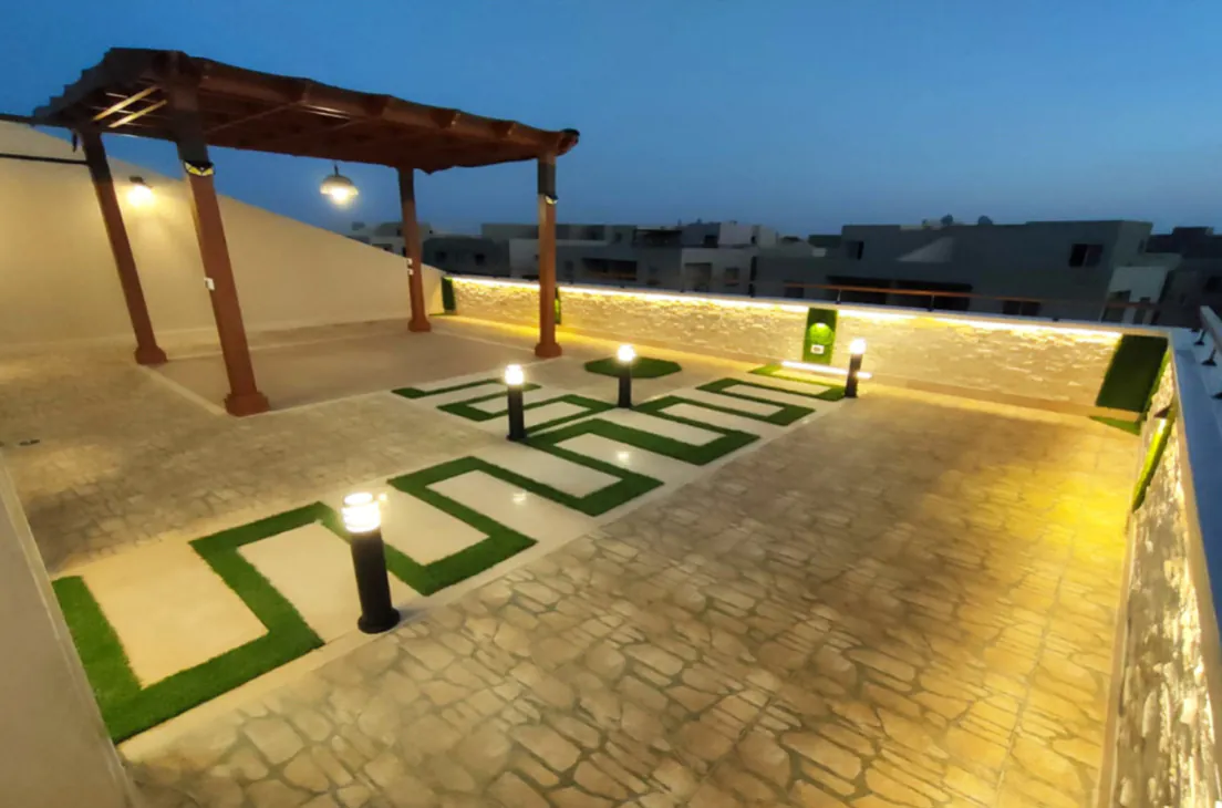 Evening outdoor setup with modern lighting, a landscaped garden, and sleek stone pathways in new cairo from Consept Art's site work portfolio.