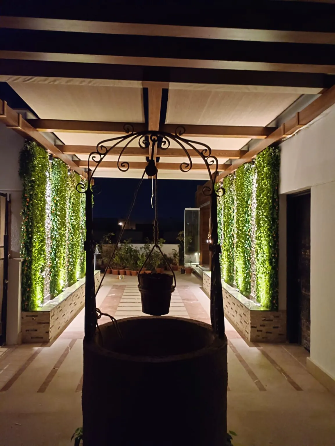 Elegant pergola with hanging planters, cozy seating, and lush greenery in the background from Consept Art's site work portfolio.